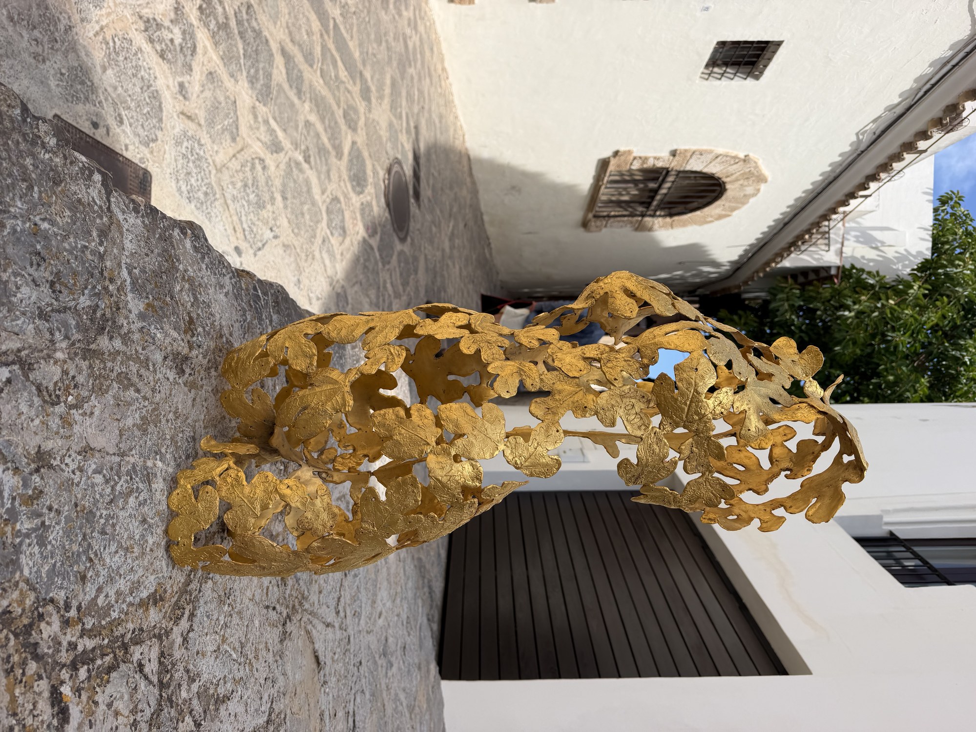 Escultura artística dorada en una calle histórica de Dalt Vila, Ibiza.